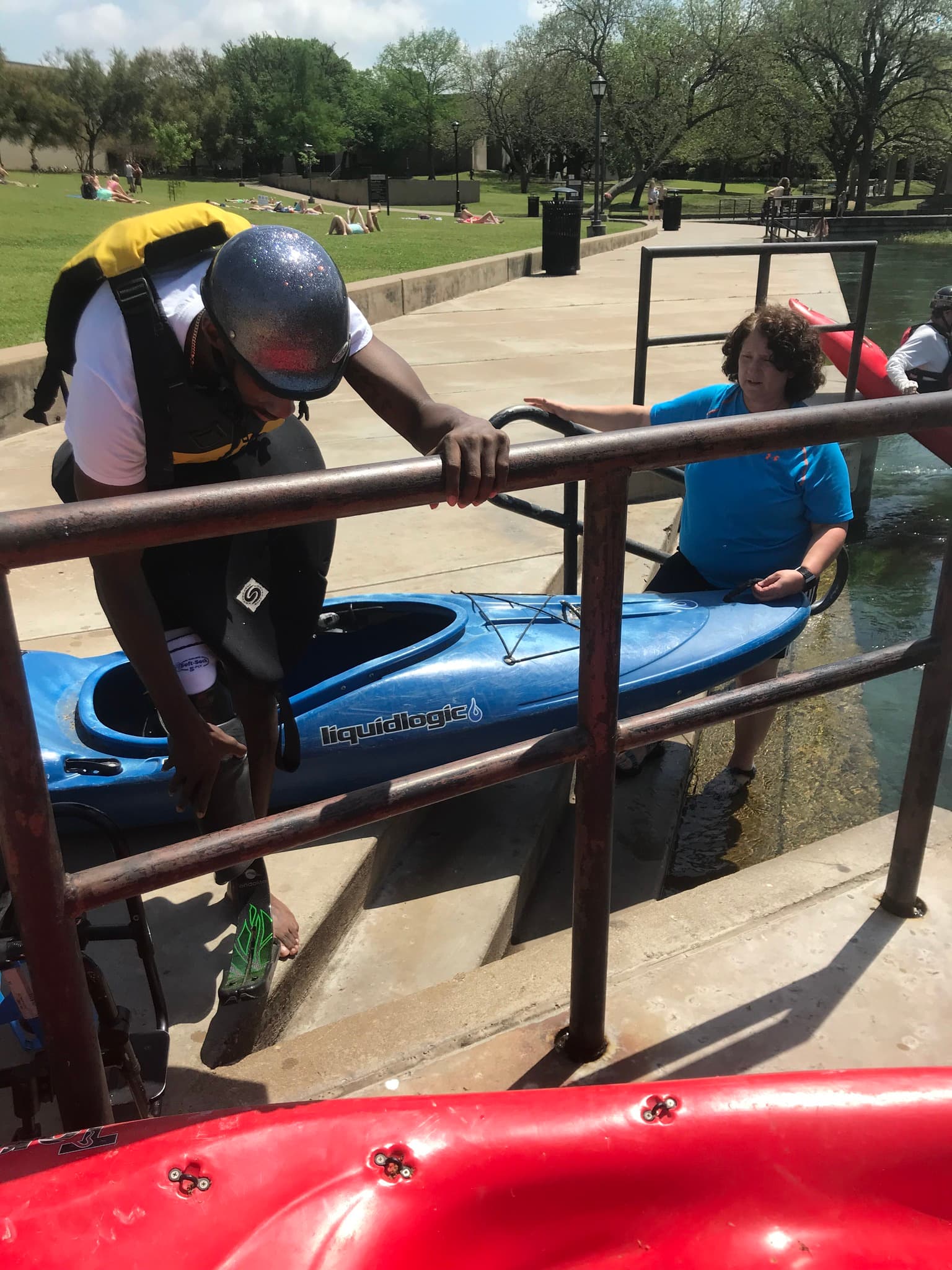 Women Lead Guide Karla Held helping an adaptive athlete into a kayak